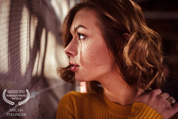 Thanks to my model @vaneschkal from Burghausen. For our shooting, we met in Bonn and every shot we took was spontaneous, also with this photo.  We saw this beautiful light passing through an inconspicuous construction site fence and I tried to create some crazy shadows on @vaneschkal's face, positioning her the right way beside the fence.